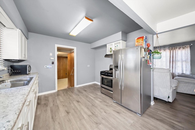 kitchen featuring white cabinetry, appliances with stainless steel finishes, light hardwood / wood-style floors, and sink