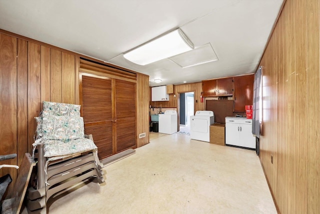 interior space featuring wooden walls and washing machine and dryer