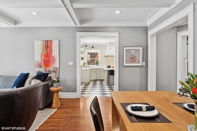 dining room with coffered ceiling, ornamental molding, and hardwood / wood-style flooring