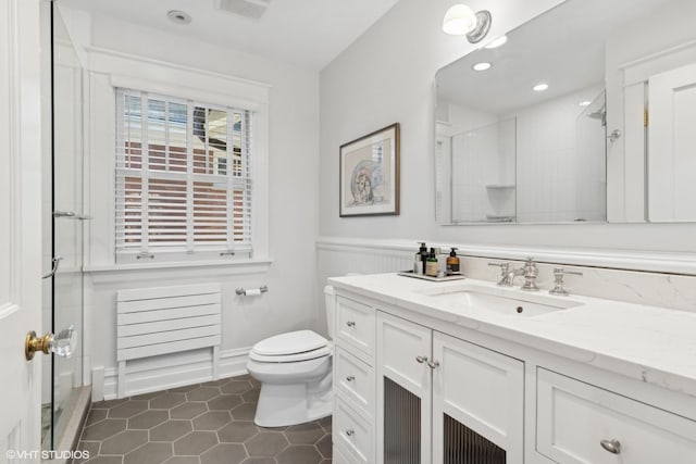 bathroom with tile patterned floors, an enclosed shower, vanity, and toilet