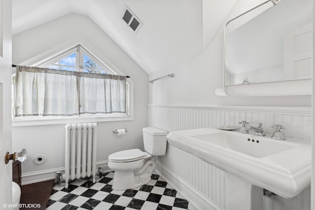 bathroom featuring sink, radiator heating unit, lofted ceiling, and toilet