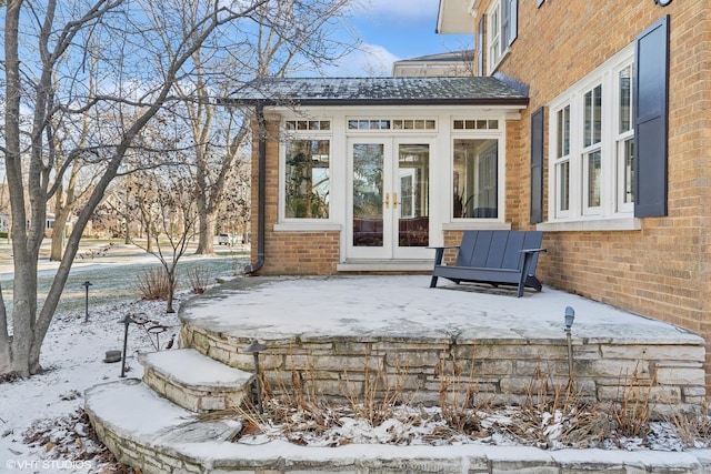 snow covered patio featuring french doors