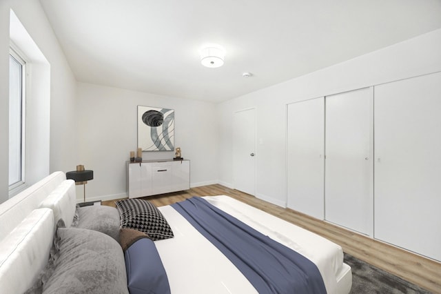 bedroom featuring a closet, baseboards, and wood finished floors