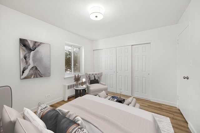 bedroom with radiator, baseboards, and wood finished floors