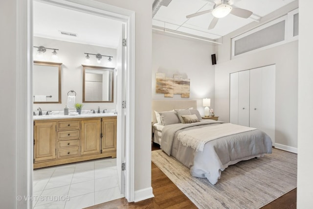 bedroom with ceiling fan, sink, a closet, and ensuite bath