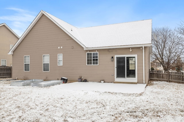 view of snow covered rear of property