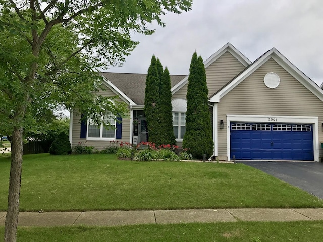 view of front of home with a garage and a front lawn