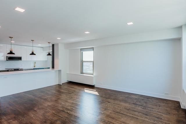 unfurnished living room featuring dark wood-type flooring