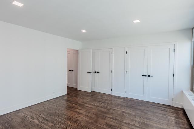 unfurnished bedroom featuring dark hardwood / wood-style flooring and multiple closets