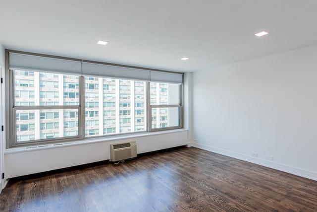 empty room with a healthy amount of sunlight, dark hardwood / wood-style flooring, and a wall mounted AC