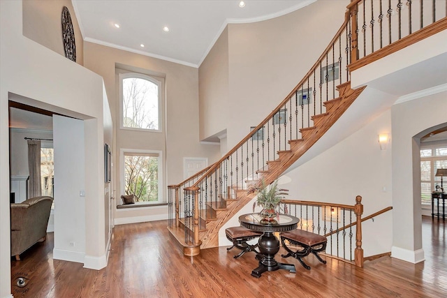 foyer featuring a healthy amount of sunlight, crown molding, and wood finished floors