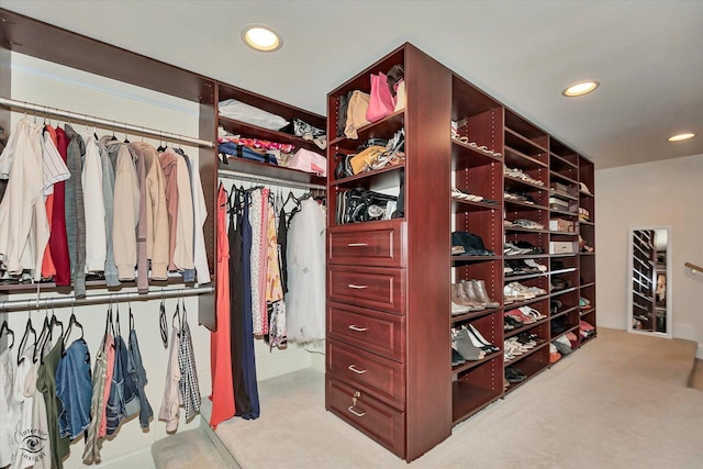 walk in closet with light colored carpet