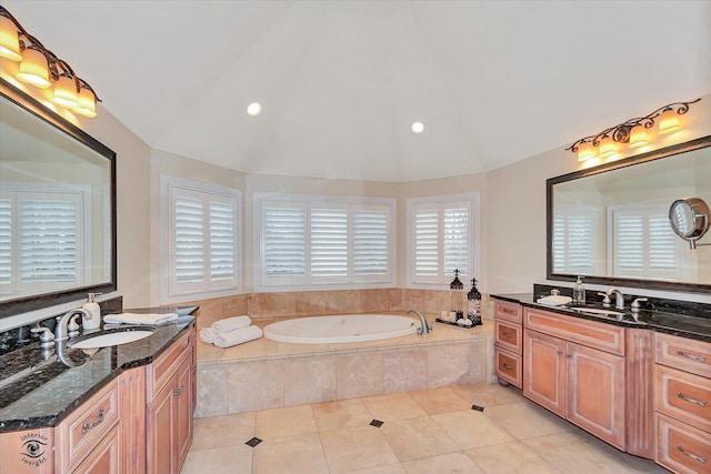 full bath featuring tile patterned flooring, vaulted ceiling, a garden tub, and a sink