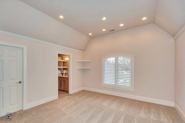 empty room with lofted ceiling, recessed lighting, baseboards, and light colored carpet