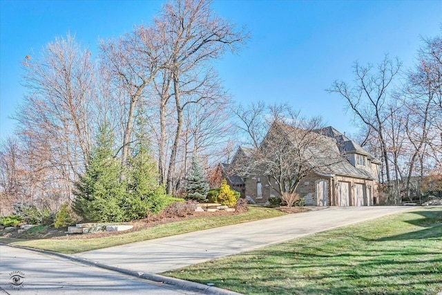 view of front of home featuring a garage, concrete driveway, and a front lawn