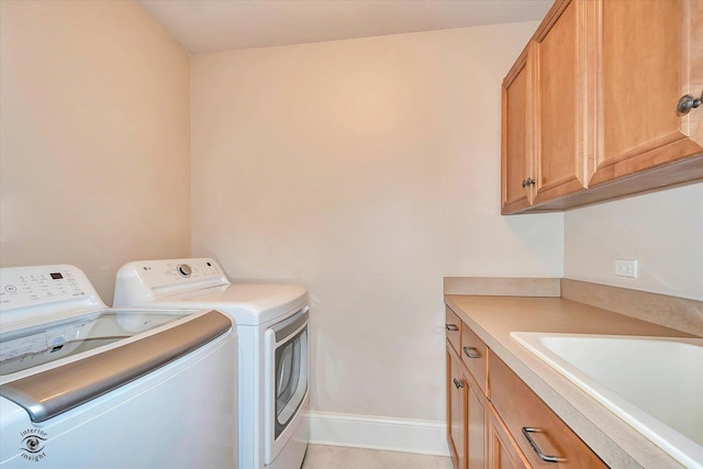 laundry area featuring cabinet space, baseboards, separate washer and dryer, and a sink