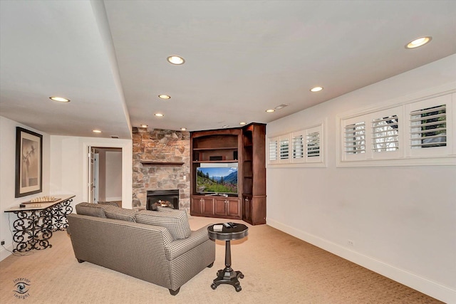 living room featuring light carpet, recessed lighting, baseboards, and a stone fireplace