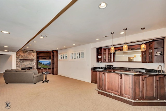 kitchen with glass insert cabinets, dark countertops, pendant lighting, and open floor plan