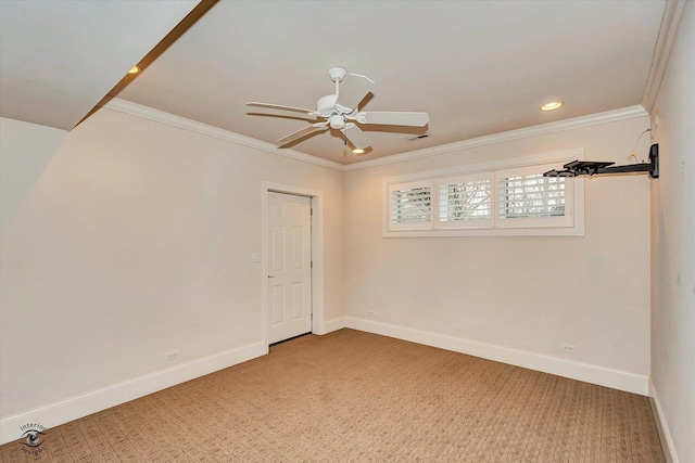 carpeted empty room with a ceiling fan, visible vents, crown molding, and baseboards