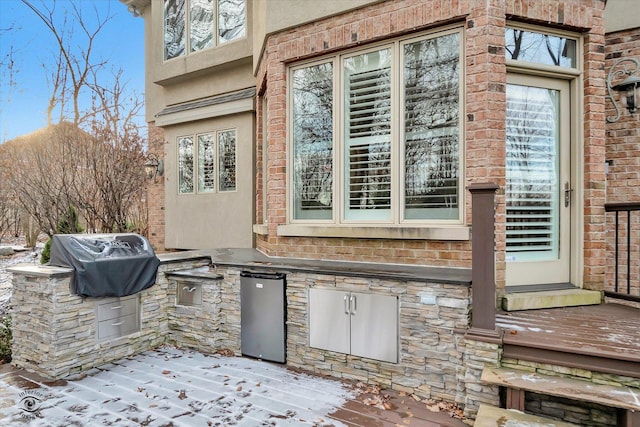 view of patio / terrace with exterior kitchen, a grill, and a deck