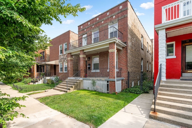 view of front facade with a balcony and a front yard