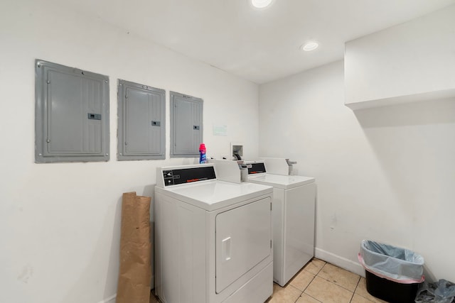 washroom with washer and dryer, light tile patterned floors, and electric panel