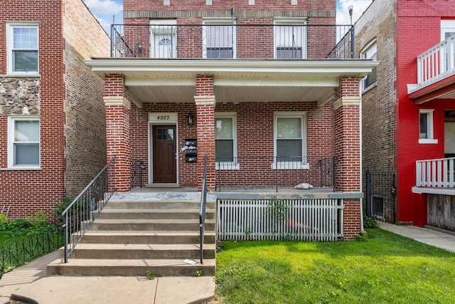 doorway to property featuring a yard and covered porch