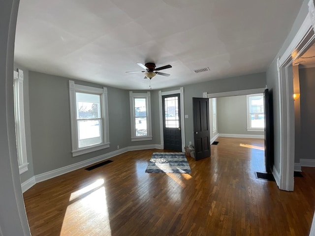 foyer entrance with ceiling fan and dark wood-type flooring