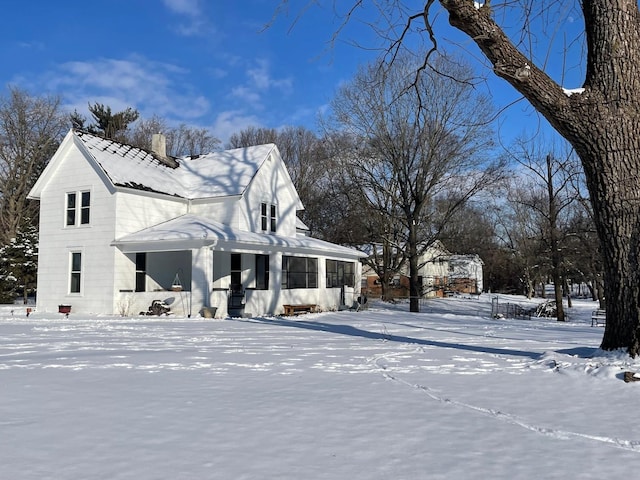 view of snow covered exterior featuring a chimney