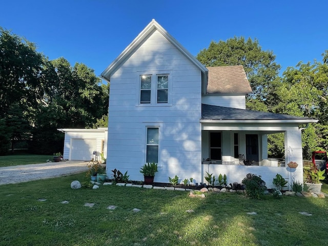 view of front of house with covered porch, roof with shingles, a front yard, and gravel driveway