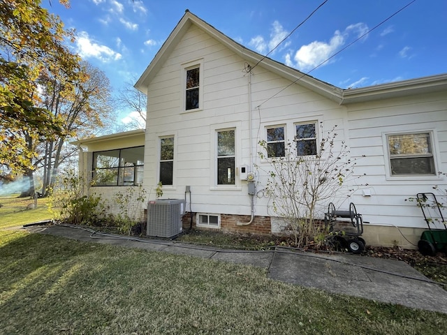 rear view of property with central AC and a lawn