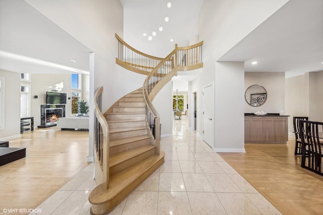 entryway with light wood-type flooring and a towering ceiling