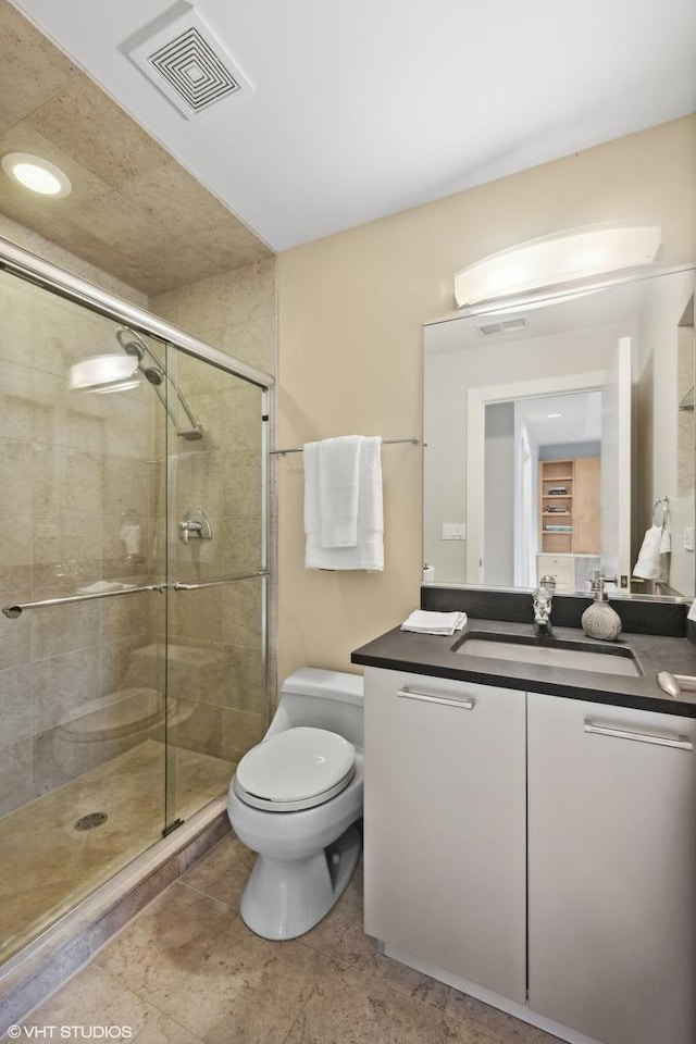 bathroom with vanity, toilet, and an enclosed shower