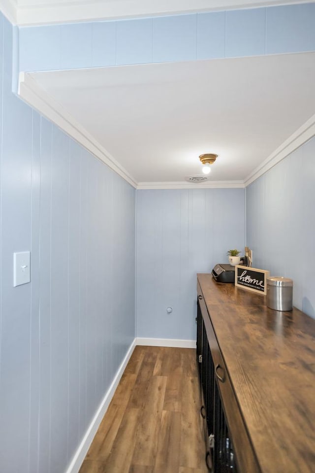 hallway with dark wood-style floors, baseboards, and crown molding