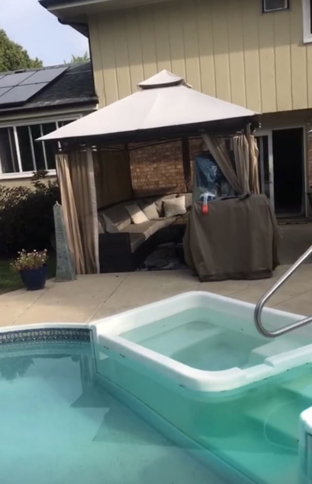 pool with a patio area and a gazebo