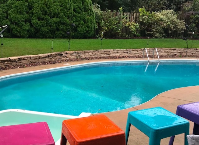 pool with fence and a lawn