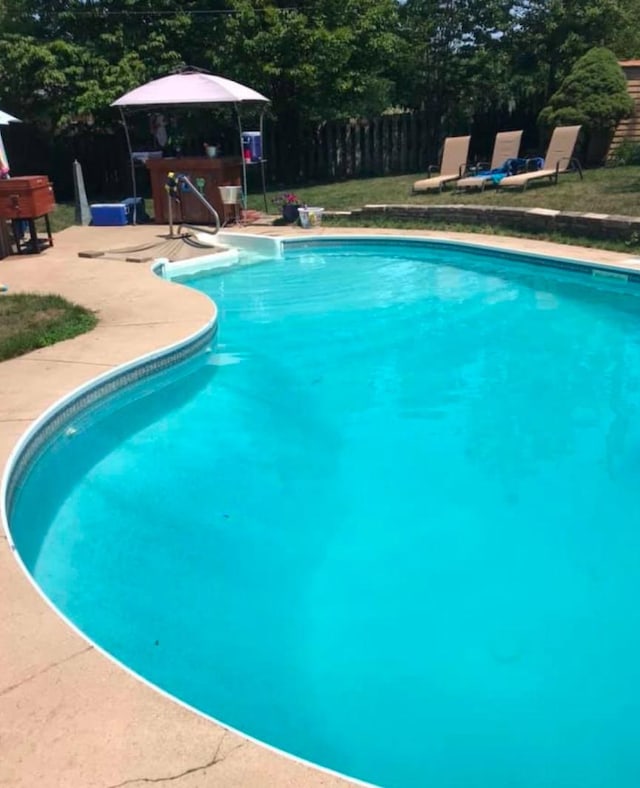 pool with fence and a patio