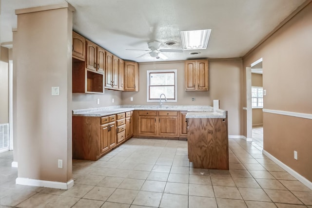 kitchen featuring ceiling fan, a skylight, plenty of natural light, and sink