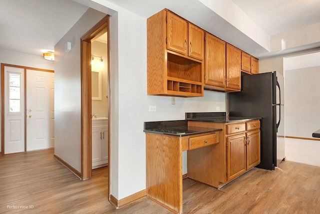 kitchen featuring sink, light hardwood / wood-style floors, and black fridge