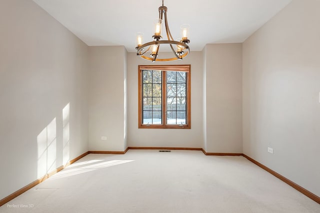 spare room with carpet flooring and a notable chandelier