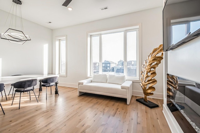 living area featuring a ceiling fan, baseboards, visible vents, recessed lighting, and light wood-type flooring