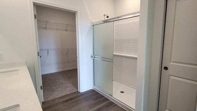 bathroom with wood-type flooring, an enclosed shower, and vanity