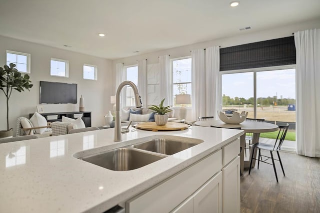 kitchen featuring white cabinetry, dark hardwood / wood-style floors, light stone countertops, and sink