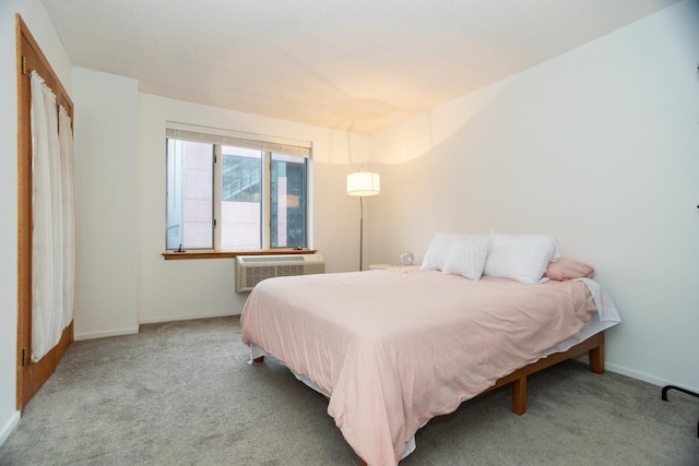 bedroom with an AC wall unit and light carpet