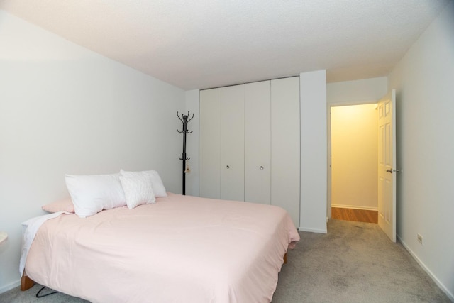 bedroom with light colored carpet and a closet