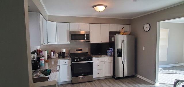 kitchen featuring light hardwood / wood-style floors, white cabinetry, light stone counters, and appliances with stainless steel finishes