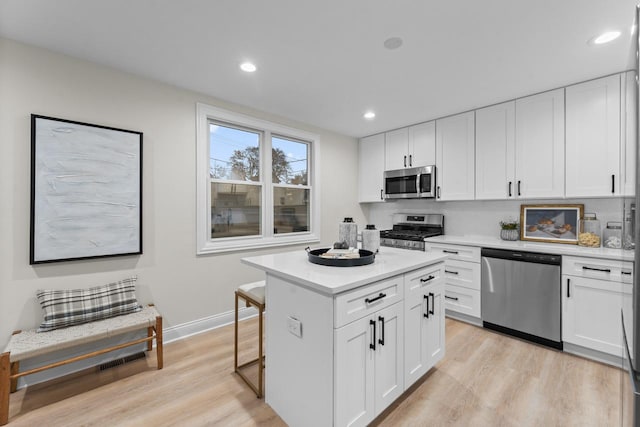 kitchen with a center island, stainless steel appliances, and white cabinetry