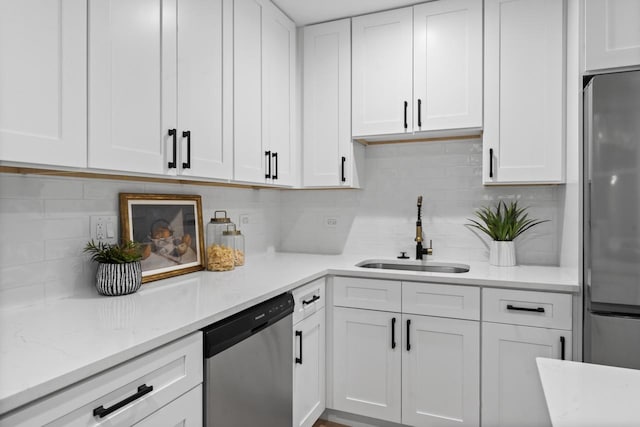 kitchen with sink, decorative backsplash, light stone countertops, white cabinetry, and stainless steel appliances