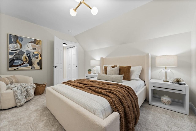 carpeted bedroom with lofted ceiling and a chandelier