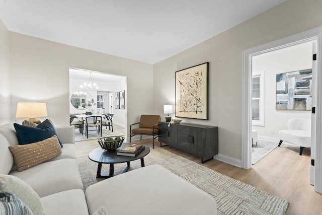 living room featuring light hardwood / wood-style flooring and a notable chandelier